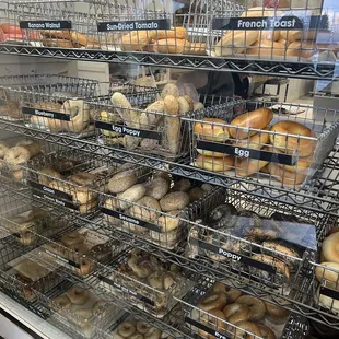 a variety of bagels in a display case