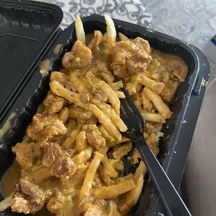 a hand holding a container of food