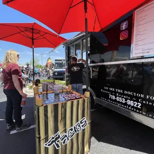 a woman standing in front of a food truck