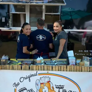 a group of people standing in front of a food truck