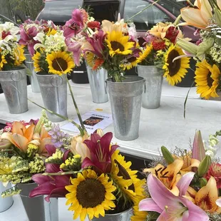 a variety of flowers in buckets