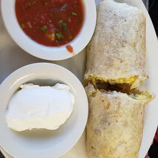 Breakfast burrito with side of sour cream.
