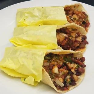 Our famous Al Pastor tacos come with cilantro, onion and our signature salsa