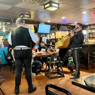 Group being sang to for birthday celebrations by mariachi band