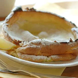 Oven Baked Dutch Baby Pancake with lemon, powdered sugar and butter.
