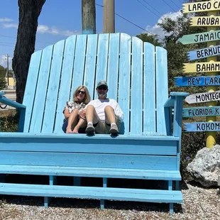 two people sitting on a blue bench