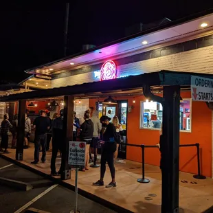 Outside. Storefront at night. Line outside to order on a Saturday evening.