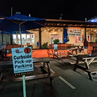 Outside. Patio. Makeshift patio in the parking lot. Also, they have curbside pick-up parking spots. Save time and call ahead.