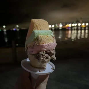 a hand holding a cone of ice cream