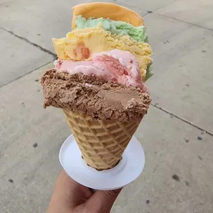 a hand holding a cone of ice cream