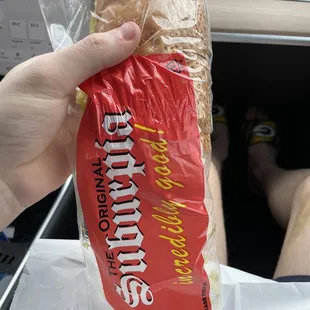 a person holding a sandwich