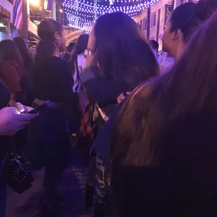 a crowd of people standing outside at night