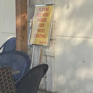 Wait to be seated sign hidden behind a pole