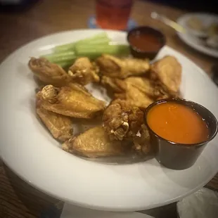 a plate of chicken wings with dipping sauce