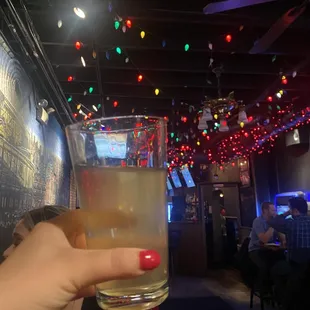 a person holding a glass of beer