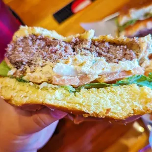 a person holding a sandwich