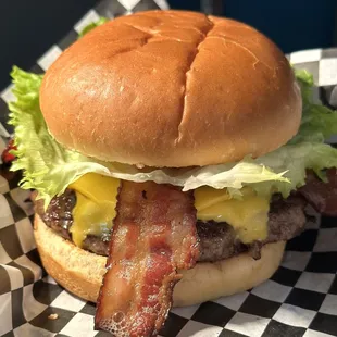 a burger with bacon and lettuce