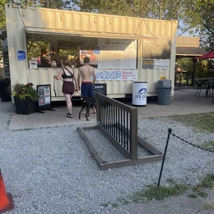 a man and a woman standing in front of a food truck