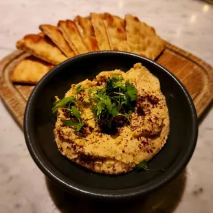 a bowl of hummus and pita chips