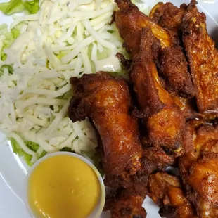 a plate of chicken wings and coleslaw