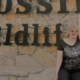 a woman standing in front of a sign
