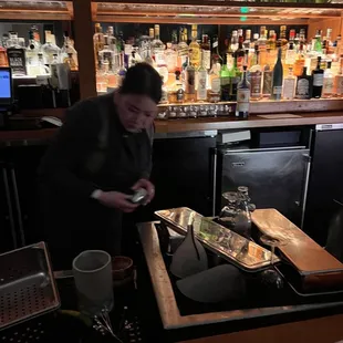 a bartender preparing a drink at a bar