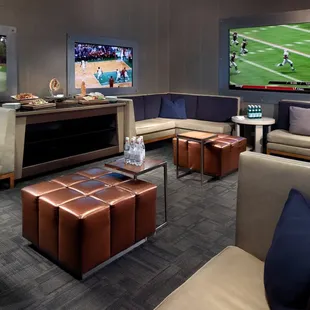 a game room with couches, tables, and televisions