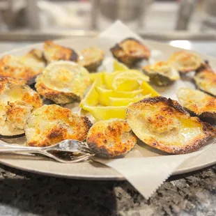 a plate of oysters with a lemon wedge