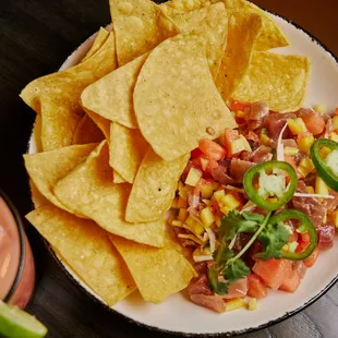 a plate of nachos and a drink