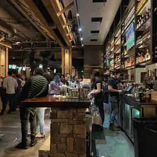 a busy bar with people standing around