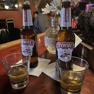 two bottles of beer and two glasses of beer