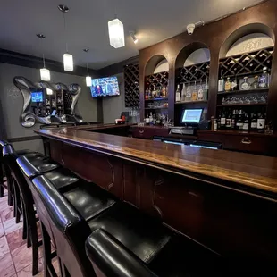 a bar with black leather stools