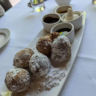 Palm Zeppole  powdered sugar, served with a trio of sauces (blueberry, chocolate, caramel, whipped cream)