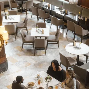 Custom banquette seating, a large community table and a unique bar design of hand-picked marble beckons guests to imbibe, gather &amp; connect.