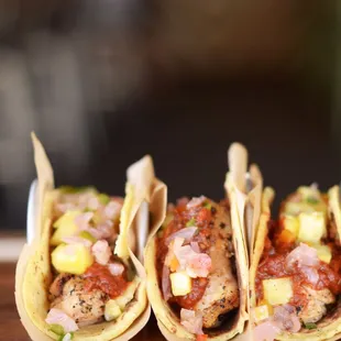 three tacos on a cutting board