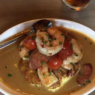 Scrimp, turkey sausage, cherry tomatoes on a bed of paleo pancakes in a Espagnole sauce garnished with fresh chives