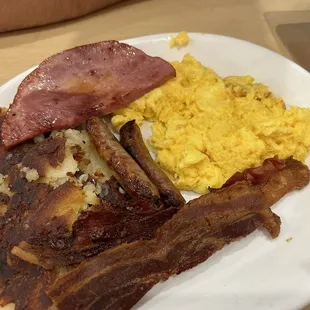 a plate of bacon, eggs, and hash browns