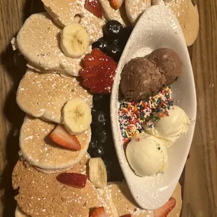 a plate of pancakes with ice cream and fruit