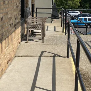 Heavy wooden chairs blocking the sidewalk for wheelchair access to the front door.