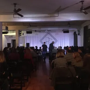 a man on a stage speaking to a group of people