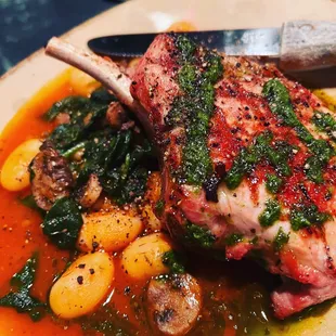 12 ounce bone in pork chop with butter beans and mushrooms cooked in tomato and herbs served with a salsa Verde!