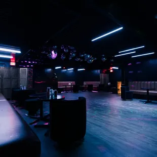 a dark room with leather couches and tables