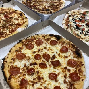 four different pizzas in boxes