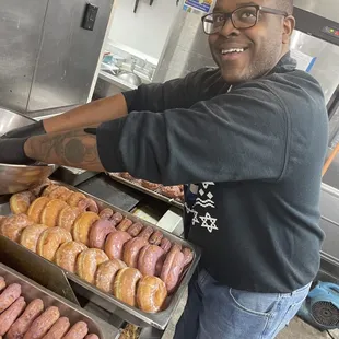 a man preparing a variety of donuts