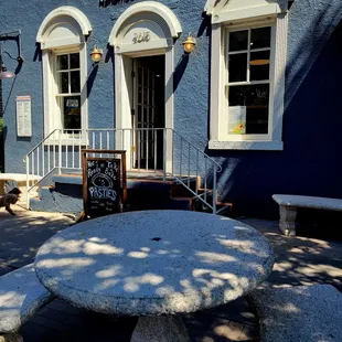 A couple tables outside, on the sidewalk