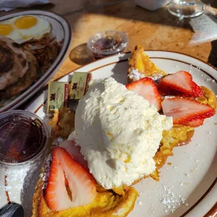 Short stack French toast with added strawberries and whipped cream