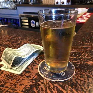 a glass of beer and money