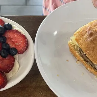 Biscuit sandwich with a side of fruit.