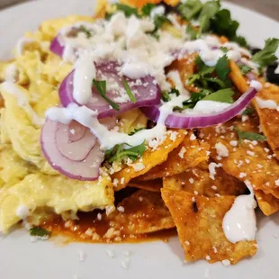 The Patio Chilaquiles: tortilla in sauce, scrambled eggs on top of black beans,  topped with red onion and cilantro drizzled with crema.