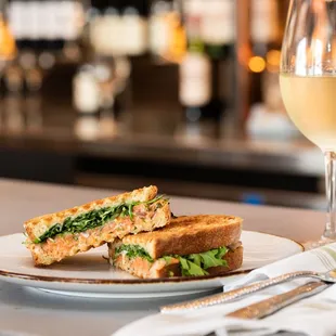 a sandwich and a glass of wine